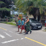 Babinsa Kodim 1710/Mimika Rutin Kawal Siswa Menyeberang Jalan